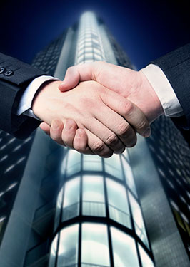 photo of handshake in front of large corporate building representing real estate attorney agreement